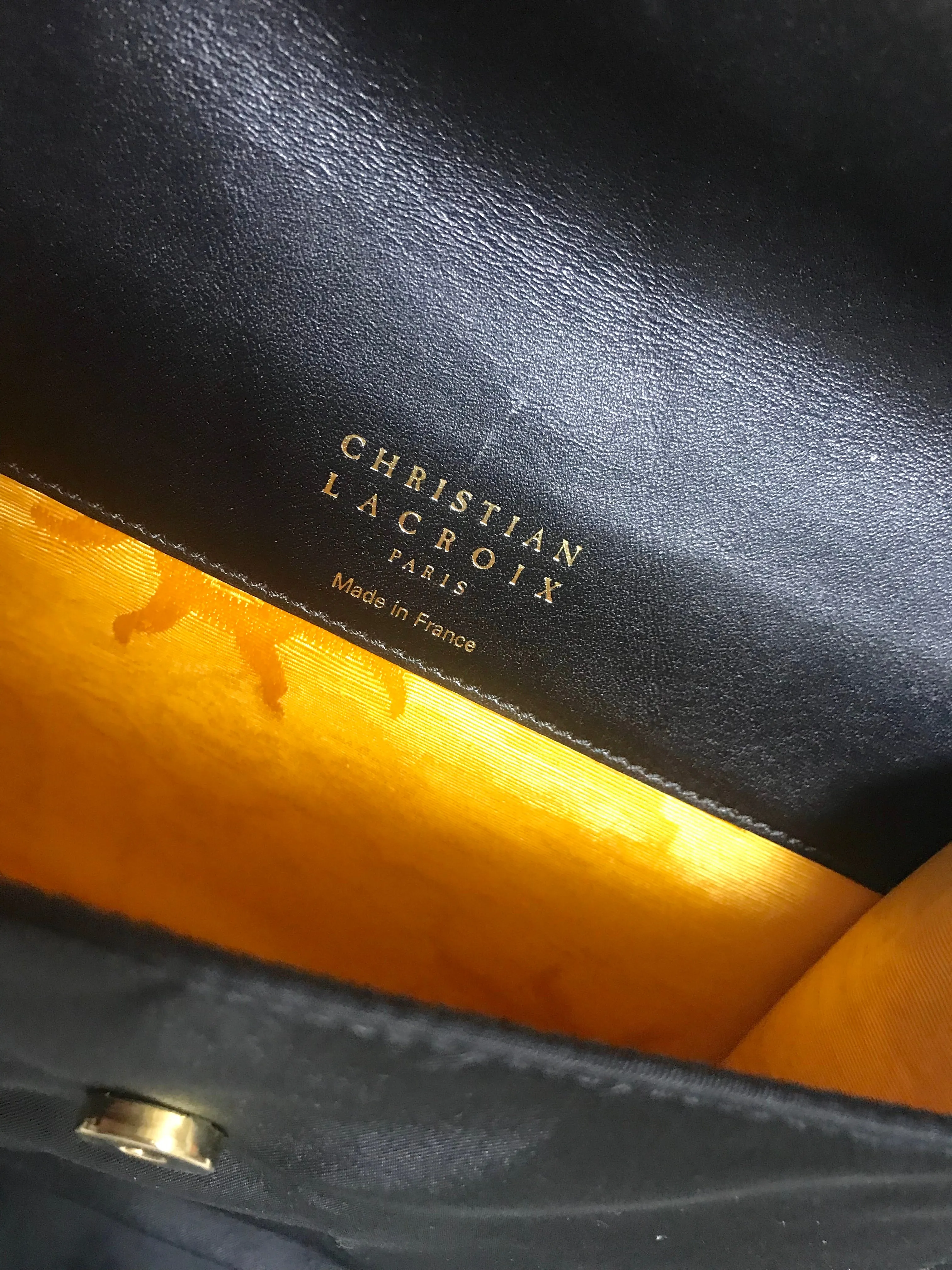 Vintage Christian Lacroix black patent enamel and nylon combo clutch bag with a sun flower shape logo motif.