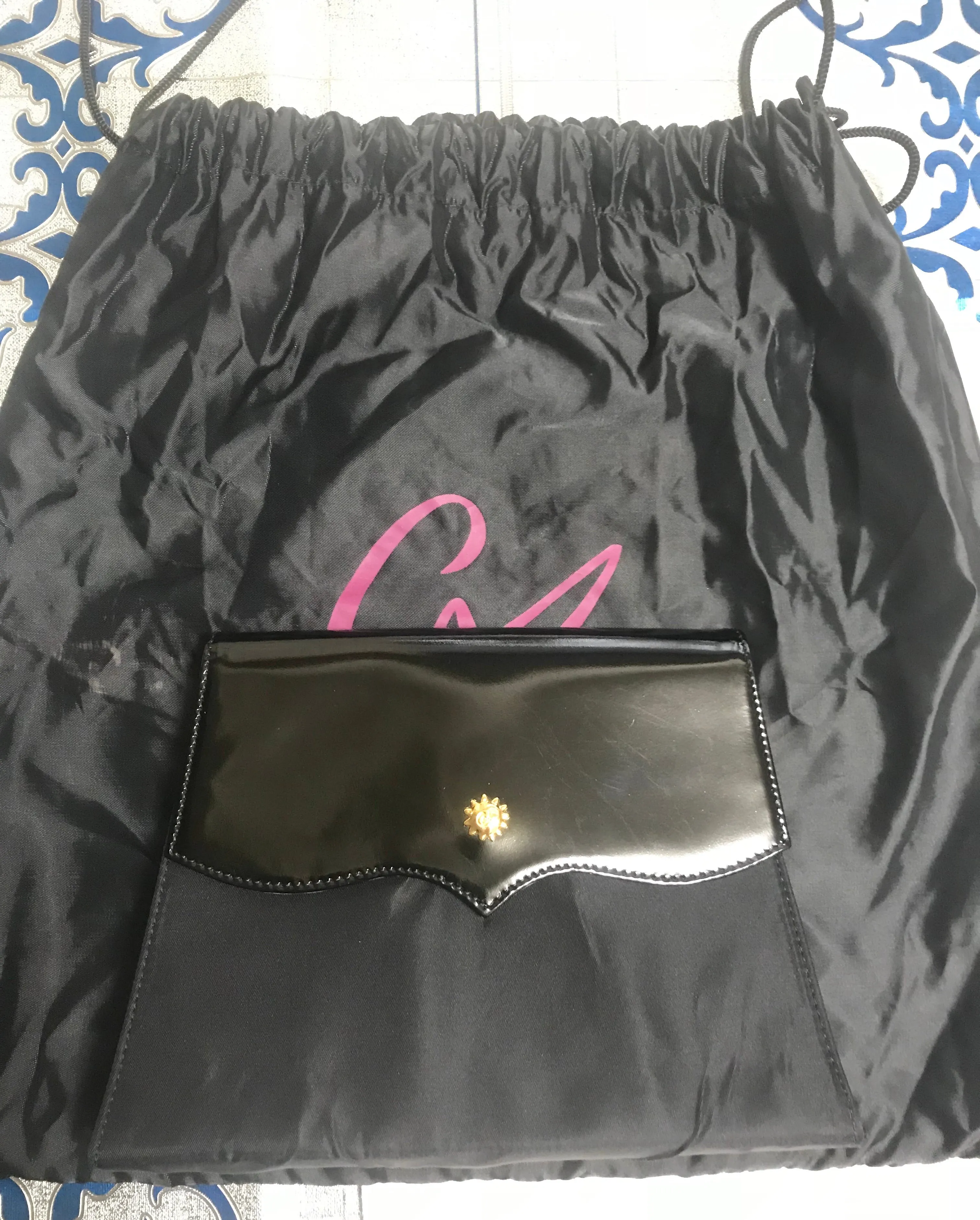 Vintage Christian Lacroix black patent enamel and nylon combo clutch bag with a sun flower shape logo motif.
